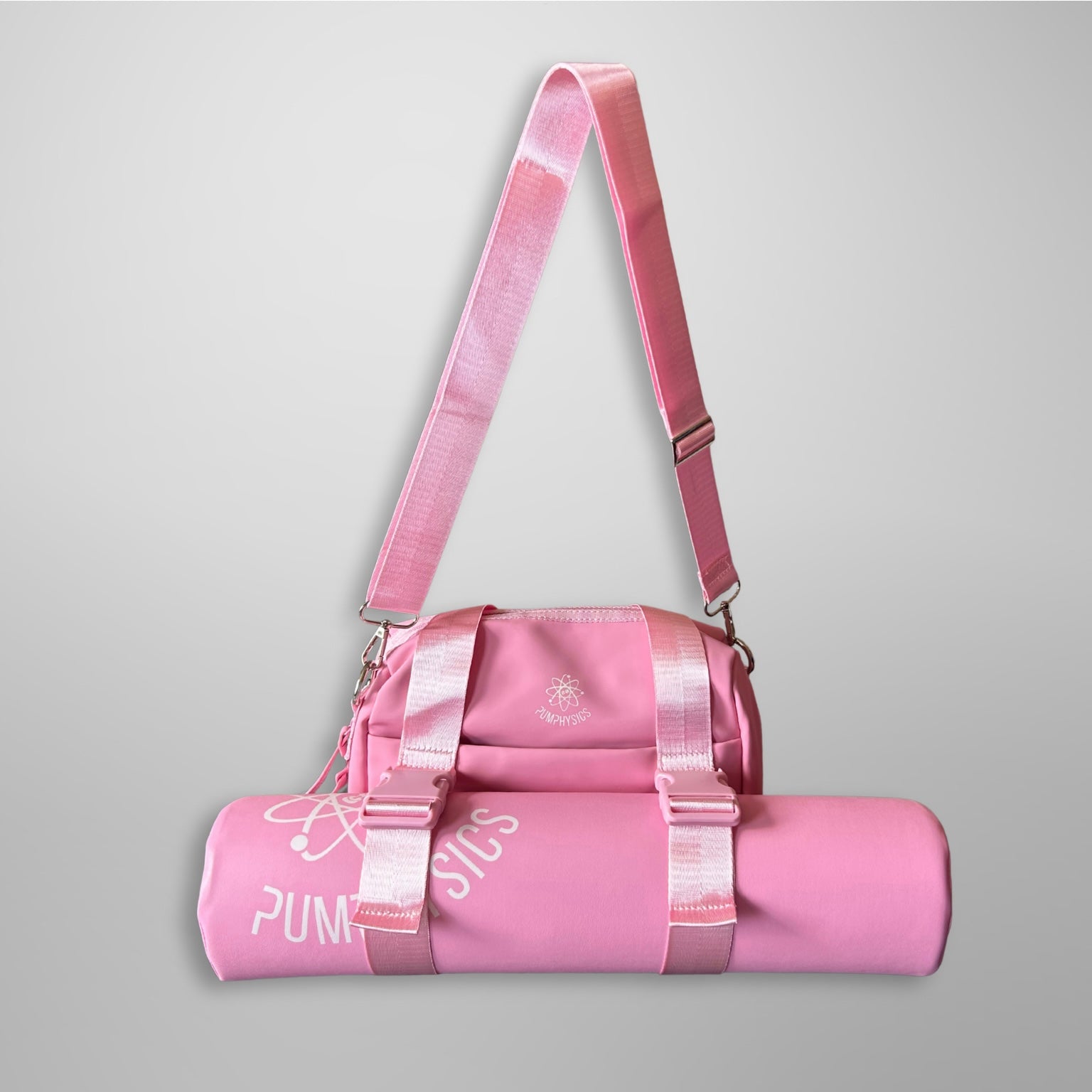 Pink duffel bag with strap on a gray background
